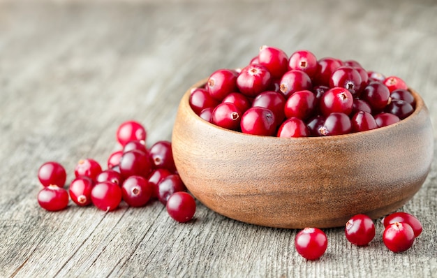 Fresh cranberries in a wooden plate on the table