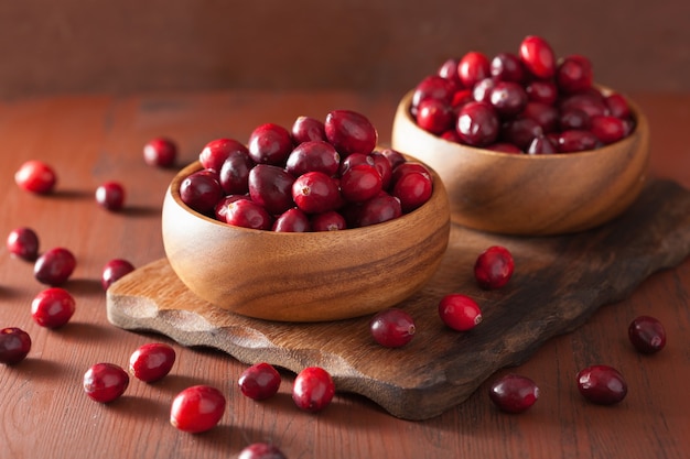 Fresh cranberry in wooden bowls over rustic table