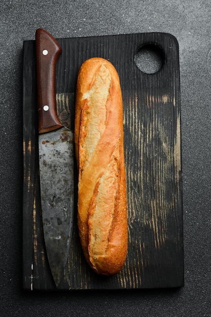 Photo fresh crispy baguette on a black slate table top view copy space