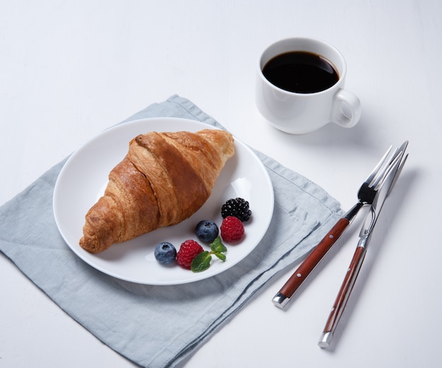 Fresh croissant with blueberries on a plate