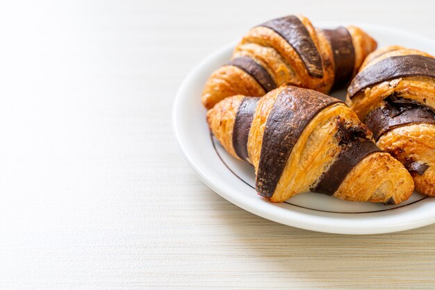 fresh croissant with chocolate on plate