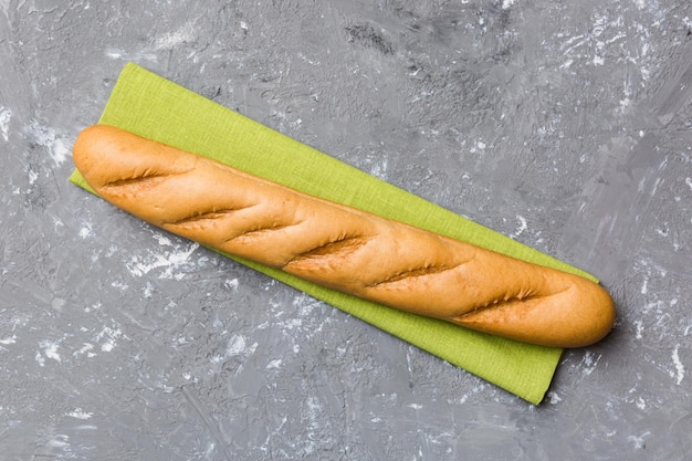 Fresh crunchy french baguette on colored table Top view Bakery products