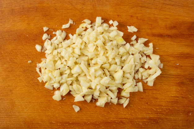 Fresh crushed garlic on wood background