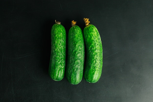 Fresh cucumber on black table