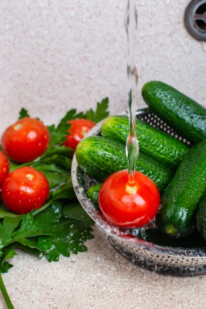 Fresh cucumbers and tomatoes in a sink