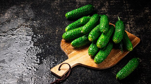 Fresh cucumbers on a wooden cutting board