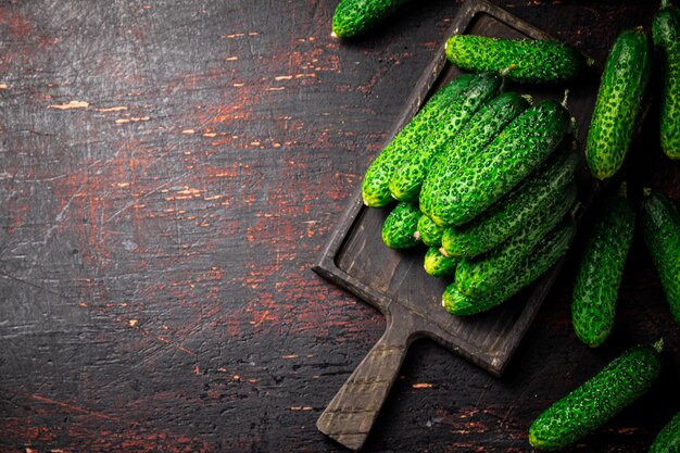 Fresh cucumbers on a wooden cutting board