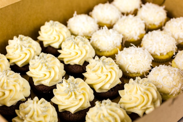 Fresh cupcakes with white icing in the box.