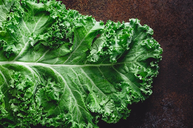 Fresh curly kale salad over dark rustic background Top view healthy eating background