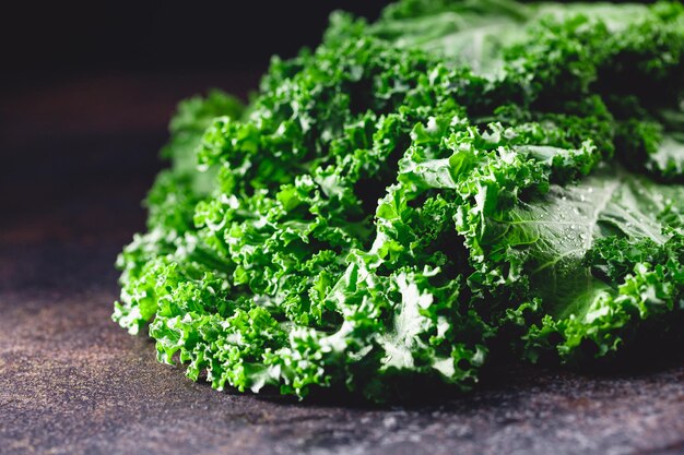 Fresh curly kale salad over dark rustic background