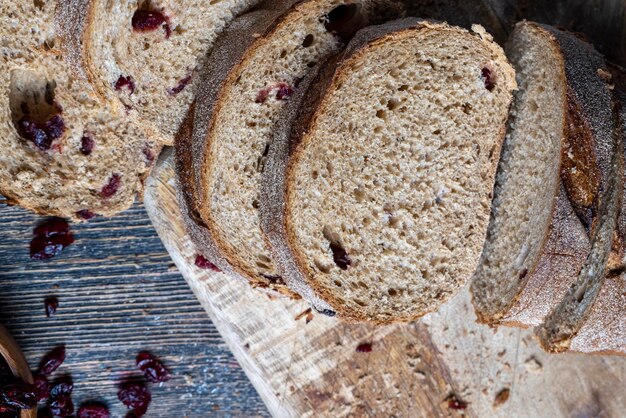 Fresh cut bread made of flour and dried cranberries red cranberry berries in bread cut into pieces