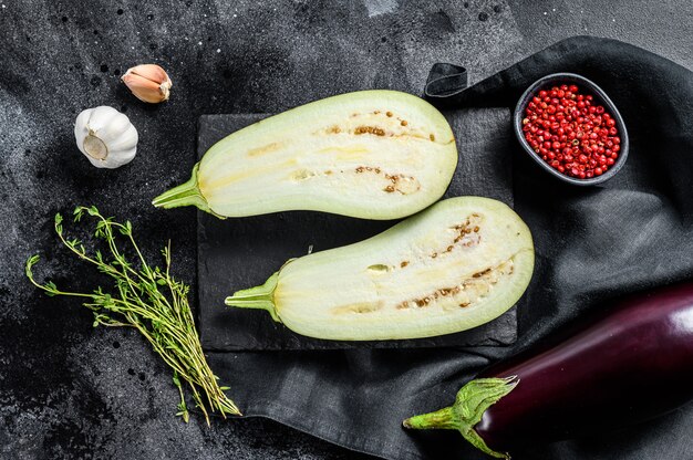 Fresh cut eggplant. Raw organic vegetables. Black background. Top view