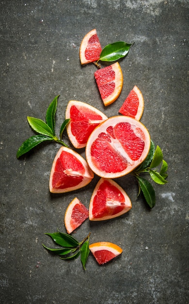 Fresh cut grapefruit with leaves on stone table. Top view