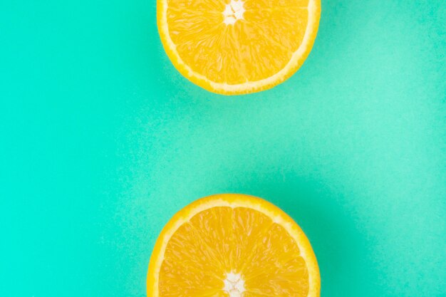 Fresh cut orange closeup on pastel green wall background. 