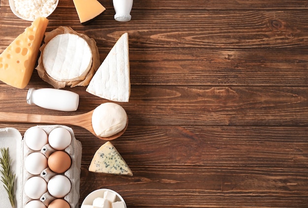 Fresh dairy products and eggs on wooden background