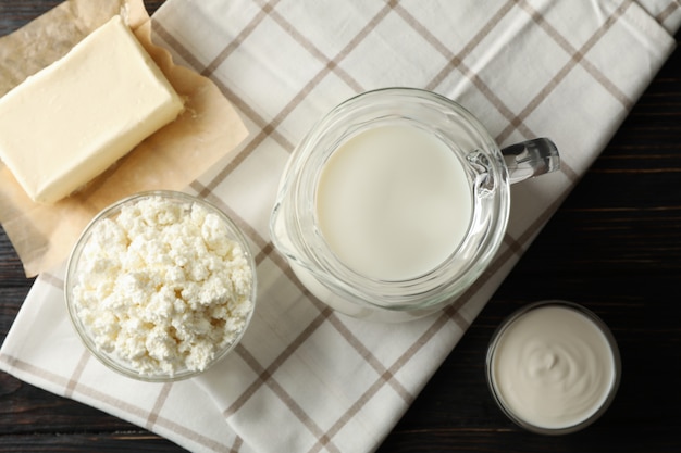 Fresh dairy products and towel on wooden background