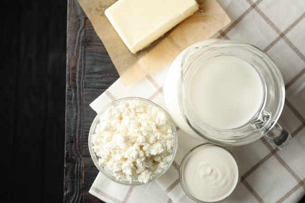 Fresh dairy products and towel on wooden background