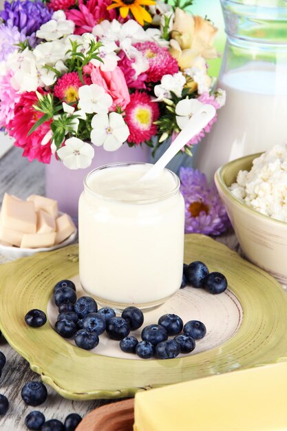Photo fresh dairy products with blueberry on wooden table closeup
