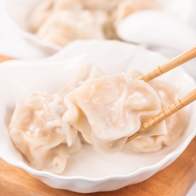 Maiale bollito fresco e delizioso, gnocchi di gyoza di gamberi su sfondo bianco con salsa di soia e bacchette, primo piano, stile di vita. concetto di design fatto in casa.