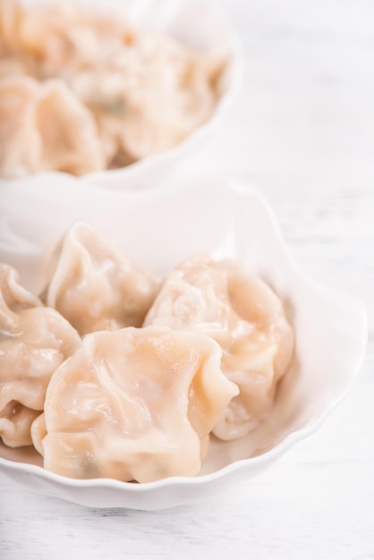 Fresh delicious boiled pork shrimp gyoza dumplings on white background with soy sauce and chopsticks close up lifestyle Homemade design concept