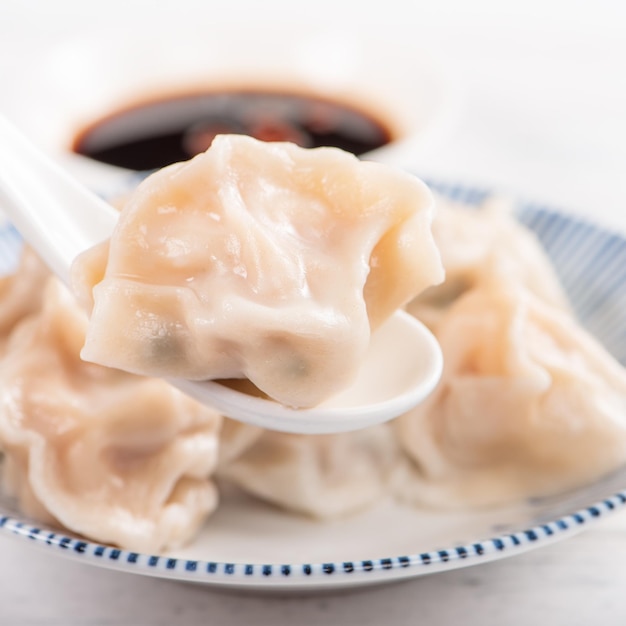 Fresh delicious boiled pork shrimp gyoza dumplings on white background with soy sauce and chopsticks close up lifestyle Homemade design concept