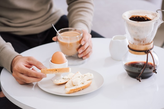 ゆで卵、カリカリのトースト、リビング ルームでのコーヒー カップでできたてのおいしい朝食