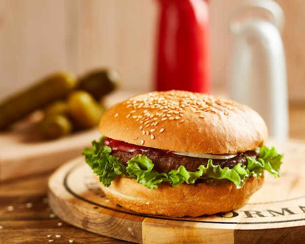 Hamburger delizioso fresco, servito su tavola di legno