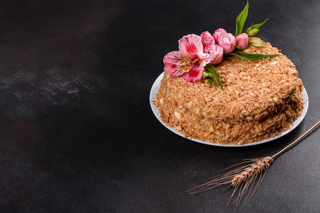 Fresh delicious cake napoleon with cream on a dark background. Cake consisting of cords and cream