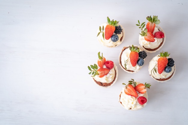 Fresh, delicious cupcakes with yogurt cream, fresh berries. Muffin with cream.