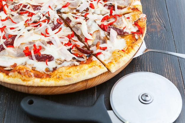 Fresh and delicious Italian pizza on a wooden table and a pizza knife