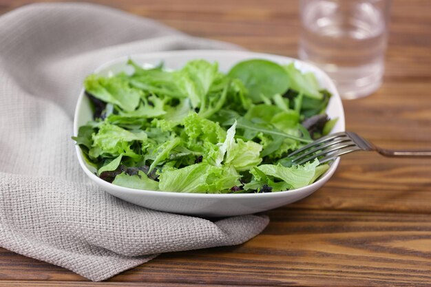 Fresh delicious salad on wooden background closeup