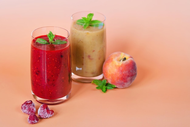 fresh delicious smoothies in a glasses made of peach, kiwi, banana and berries. Healthy detox drink