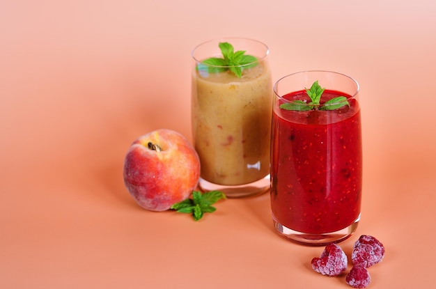 fresh delicious smoothies in a glasses made of peach, kiwi, banana and berries. Healthy detox drink