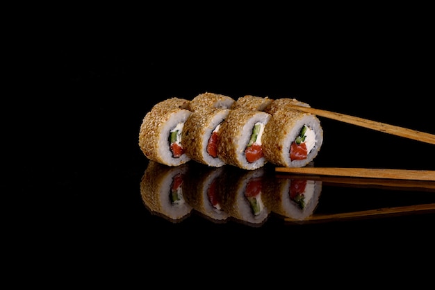 Свежие вкусные суши-роллы на темном фоне