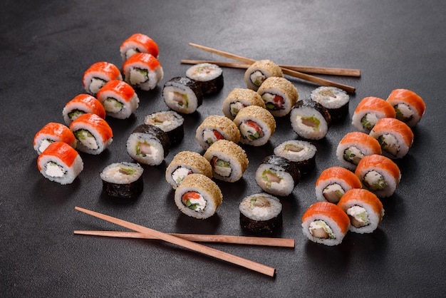 Свежие вкусные суши-роллы на темном фоне