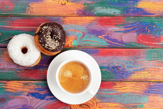 Fresh donut with coffee on wooden surface