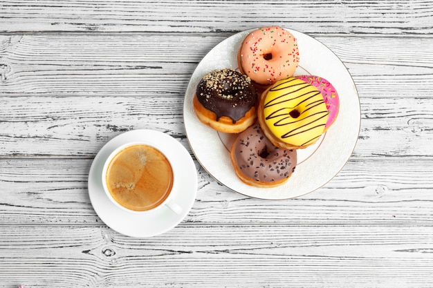 Fresh donut with coffee on wooden surface