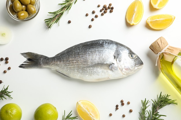 Pesce fresco di dorado, spezie ed ingredienti di cottura su bianco