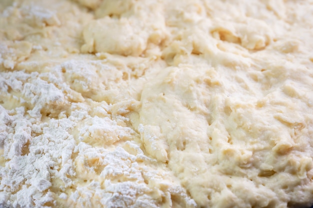 Fresh dough with flour as background