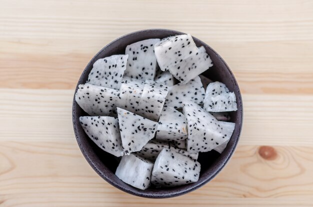 Fresh dragon fruits slices in black bowl