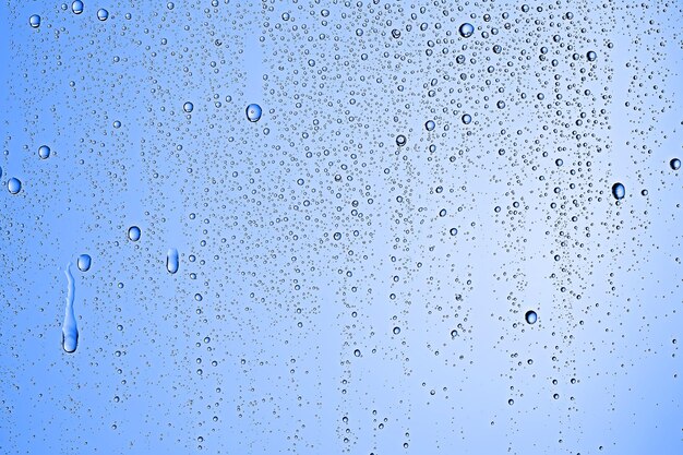 Photo fresh drops background blue glass / wet rainy background, water drops transparent glass blue
