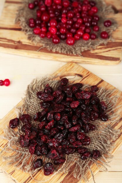 Fresh and dry cranberry on wooden table closeup