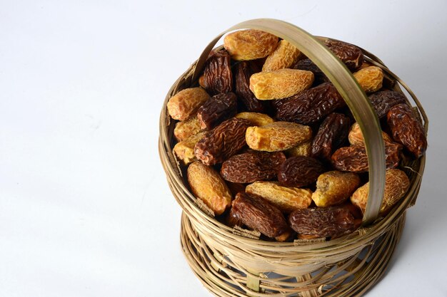 Photo fresh dry dates in the wooden bowl, organic, border white background, wooden background.