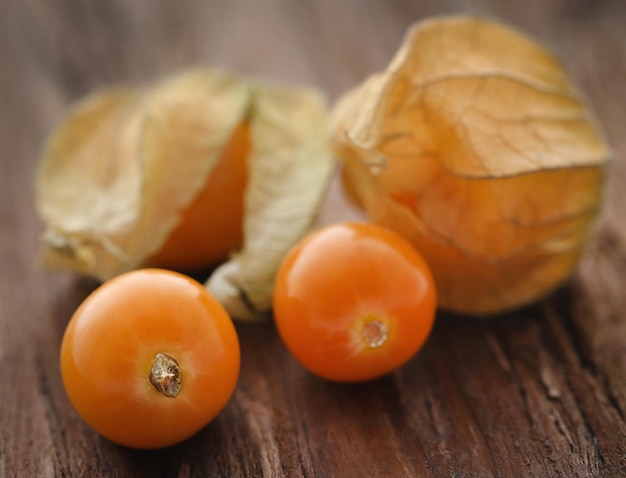 Fresh edible physalis on wooden surface