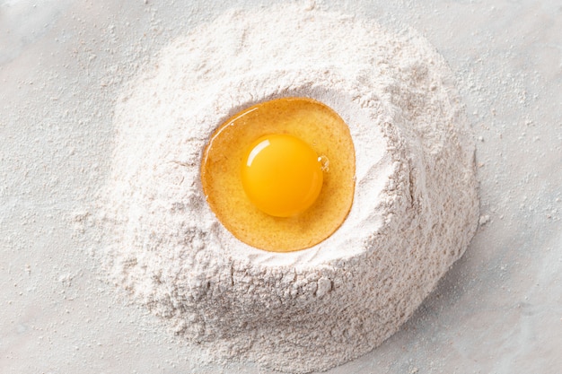 Fresh egg in a heap of whole grain flour