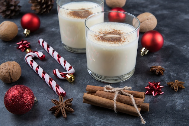 Fresh eggnog with cinnamon with christmas decorations. Copy space, low key.