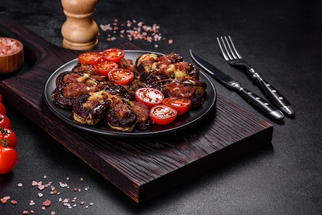 Fresh eggplant baked with minced meat spices and herbs on a black plate