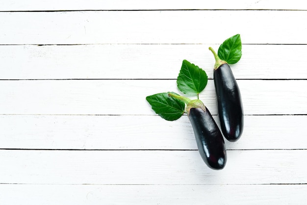 Fresh eggplant on a white wooden background. Vegetables. Top view. Free copy space.