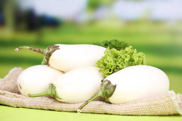 Fresh eggplants on table on bright background