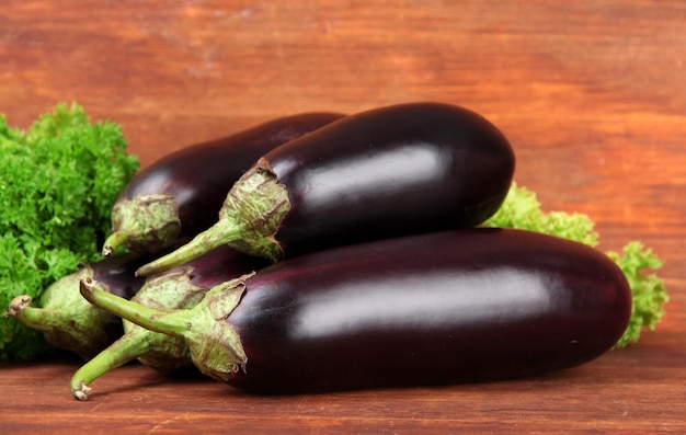 Fresh eggplants on table on wooden background